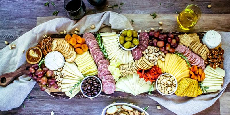 Charcuterie board with salami, olives, cheese, and wine