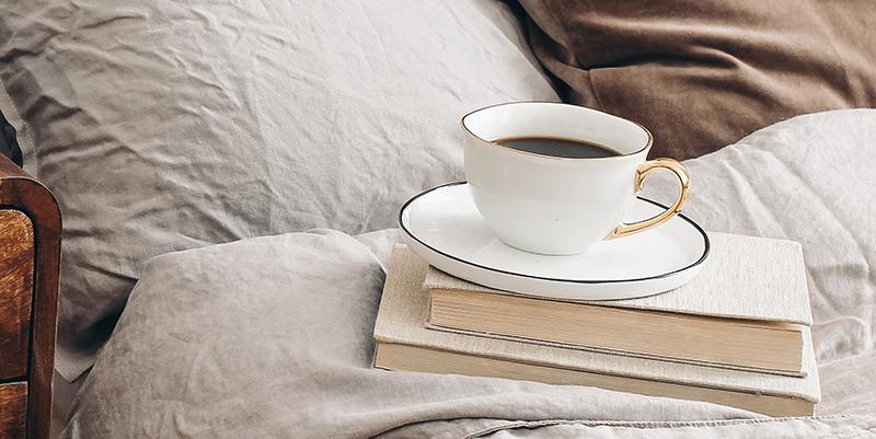 decaf coffee cup on books in bedroom