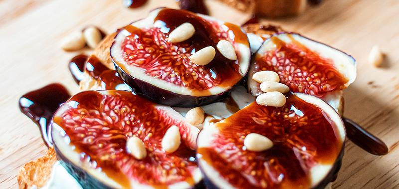 Figs with balsamic glaze on crostini with nuts and cheese spread