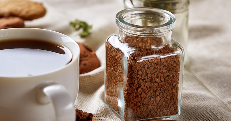 Instant coffee next to a cup of black coffee