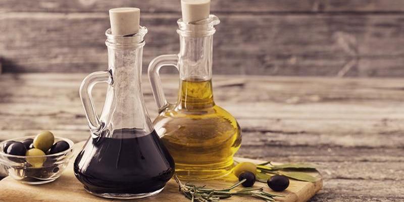 Olive oil and vinegar cruets with green olives and black olives