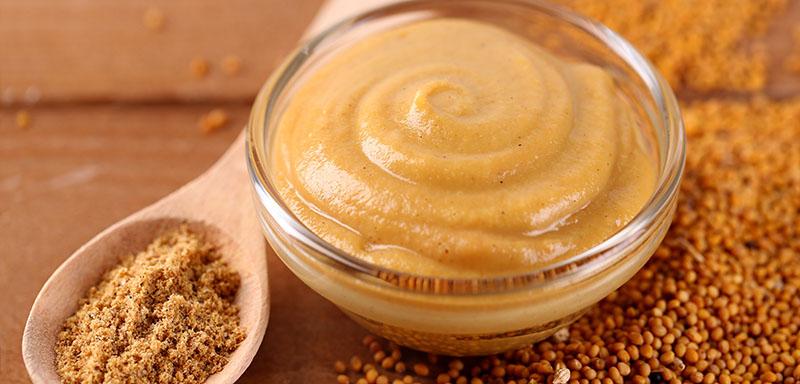 Bowl of mustard with ground mustard and mustard seeds