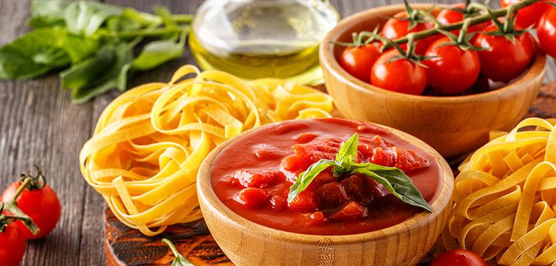bowl of tomato sauce with dry tagliatelle pasta